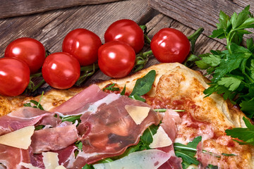 Homemade fresh delicious gourmet pizza whit grana cheese, raw ham and rocket ,Tasty italian pizza isolated on wooden table,Close up with selective focus