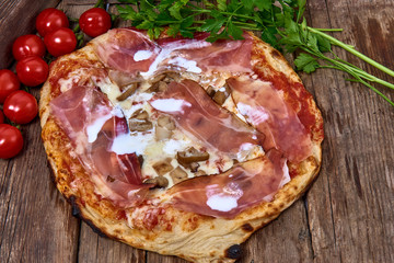 Homemade fresh delicious gourmet pizza whit liquid cream,porcini mushrooms and speck ,Tasty italian pizza isolated on wooden table,Close up with selective focus