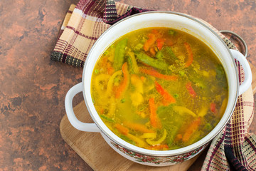Freshly brewed summer vegetable soup in enamel saucepan