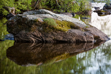 Fototapeta na wymiar Rock on water reflection