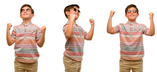 Handsome toddler child with green eyes happy and excited celebrating victory expressing big success, power, energy and positive emotions. Celebrates new job joyful