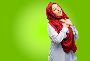 Young arab woman wearing hijab with hands in heart, expressing love and health concept