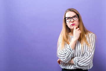 Fototapeta premium Young woman in a thoughtful pose on a solid background