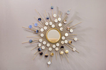 Decorative wall round mirror in the shape of the sun, a golden cooper mirror, modern shape in the...