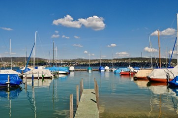 Fototapeta na wymiar Blick auf den Zürichsee am Schiff - Hafen der Stadt Zürich. Segelboote, Schiffe, und Boote in der Hafenanlage am See