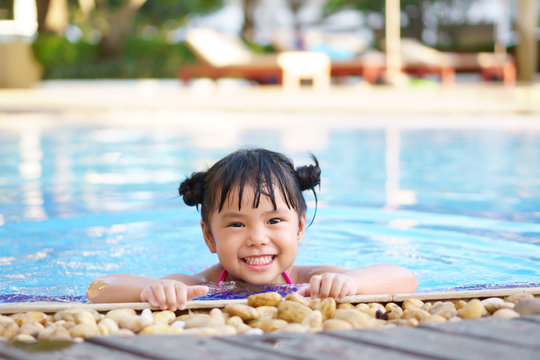 Asian Children Cute Or Kid Girl Swimming And Smile With Happy Fun On Swimming Pool Or Water Park For Refreshing And Relax With Exercise At Summer Holiday Travel