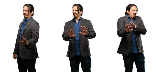 Handsome young man disgusted and angry, keeping hands in stop gesture, as a defense, shouting