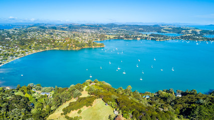 Obraz premium Aerial view on beautiful bay at sunny day with sandy beach and residential houses on the background. Waiheke Island, Auckland, New Zealand