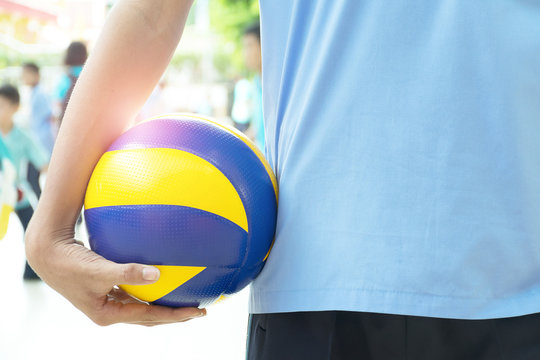 Volleyball players hold the ball with their right hand.
