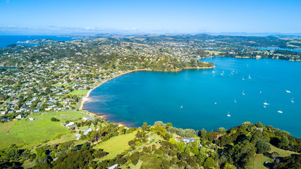Obraz premium Aerial view on sunny beach with residential houses. Waiheke Island, Auckland, New Zealand