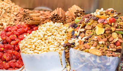 Healthy food background. Sweet energy  dry fruits and nuts mix,cashew, red berry, cinnamon sticks on the counter at market . Selective focus.