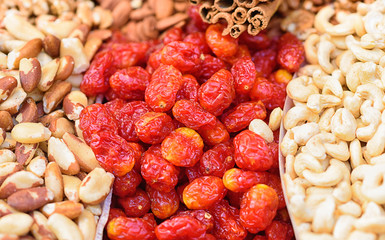 Healthy food background. Sweet energy  dry fruits ,cashew, red berry, cinnamon stick, Brazil nuts on the counter at market . Selective focus.