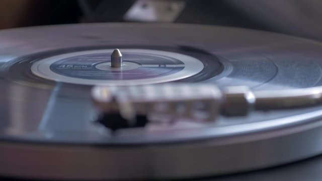 Rack focus close up shot of vinyl record playing on turntable
