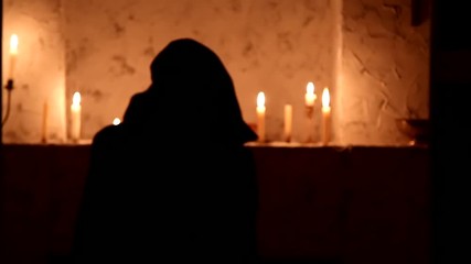 The monk walks the dark room to the altar