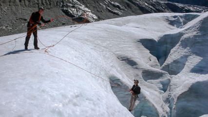 two mountain climbers training their crevasse rescue skills on a glacier in the Alps