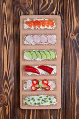 Tasty vegetarian sandwiches on wooden background. Space for text or design.