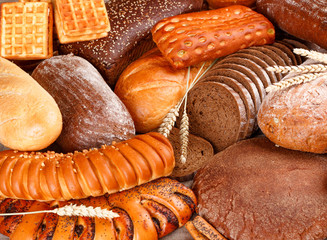Freshly baked rye and wheat bread on the table. Whole and sliced loaves