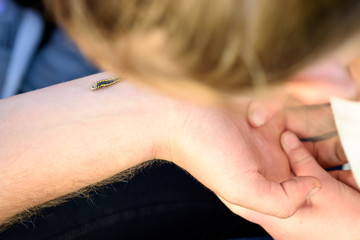 Close up of Caterpillar on man's hand.A teacher with child in nature class. A lesson about caterpillar in summer garden.