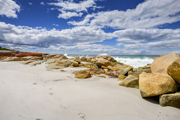 Beautiful sunny summer coast view from Bay Of Fires to blue Tasman Sea with crystal clear water surrounded by red orange colorful shore rocks and white sandy beach, Cosy Corner, Tasmania, Australia