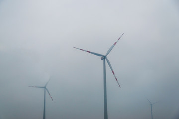 Fototapeta premium wind turbines on the background of smog, Eco power concept