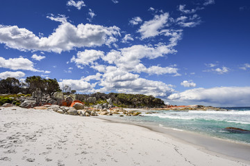 Fototapeta na wymiar Beautiful sunny summer coast view from Bay Of Fires to blue Tasman Sea with crystal clear water surrounded by red orange colorful shore rocks and white sandy beach, Cosy Corner, Tasmania, Australia