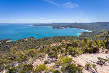 Wonderful view to stunning sandy beach blue turqouise water on warm sunny day with blue sky relaxing after hiking on top Mount Amos, Wineglass, Freycinet National Park, Coles Bay, Tasmania, Australia