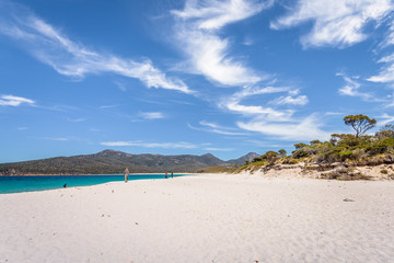 Relaxing amazing view to stunning sandy beach blue turqouise water enjoy swiming warm sunny day with blue sky after hiking on top mountains, Freycinet National Park, Wineglass Bay, Tasmania, Australia
