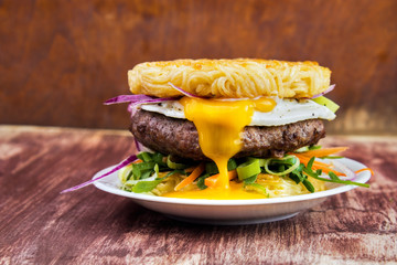 Ramen beef burger with egg, carrot strips , chives , red onion and fried egg , bun made of noodles - 201689142