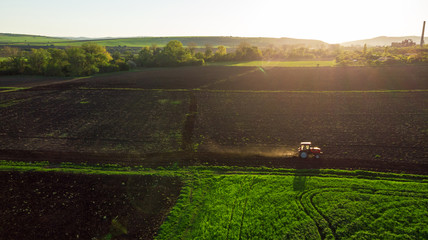 Naklejka premium Aerial view of tractor at sunset.