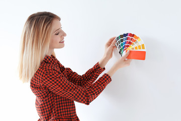 Young woman with color palette on white background