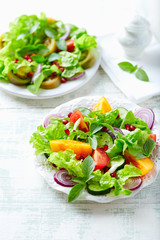Red and yellow fresh tomato salad with  with pomegranate seeds