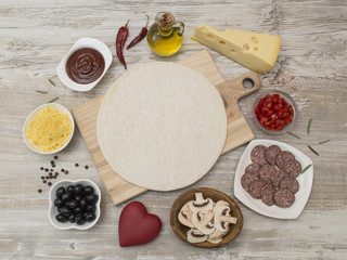 ingredients for pizza making on a wooden table. 