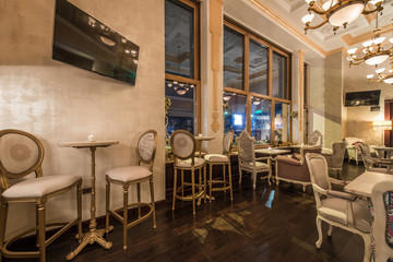 Golden old fasioned stools and tables in luxury restaurant