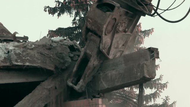 Rise of machines, close up shot of strong demolition tool removing house ruins