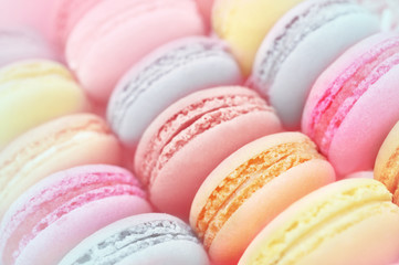 Colorful macarons on pastel festive decor background, selective focus