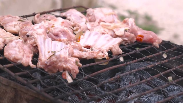 Male hand putting minced meat kebabs on barbecue.