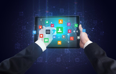 Hand using tablet with colorful bounce application symbols and icons concept

