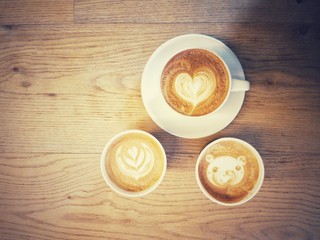 Cup of coffee with a lot of beautiful latte art on wooden table with vintage style