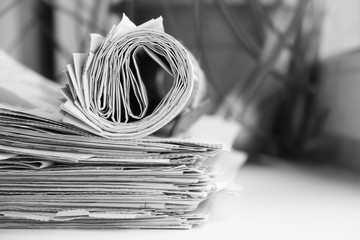 Pile of newspapers and rolled journal. News and finance information in daily papers, concept for business