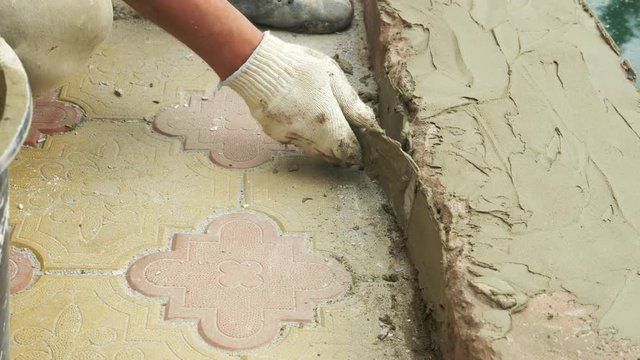 spatula and bucket with mortar on the construction site. the builder finishes the surface with plaster. 4k. pool repair.