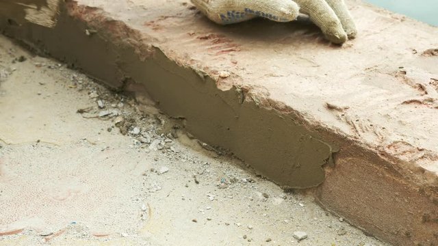 spatula and bucket with mortar on the construction site. the builder finishes the surface with plaster. 4k. pool repair.