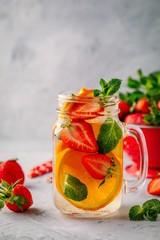 Infused detox water with orange, strawberry and mint. Ice cold summer cocktail or lemonade.