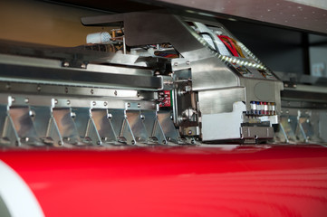 Wide-format inkjet printer during printing on vinyl film, closeup