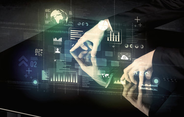 Businessman touching interactive modern desk with technology icons on table