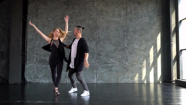 Young couple dancing. Dance on a gray background. slow-motion