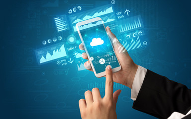Female hand using smartphone with financial tracking concept illustrated by graphs and symbols