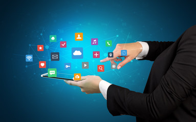 Female hand touching tablet with application icons above