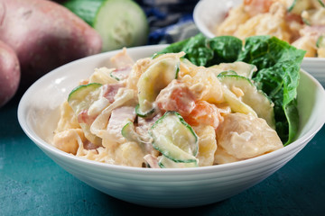 Delicious potato salad with ham, egg and cucumber