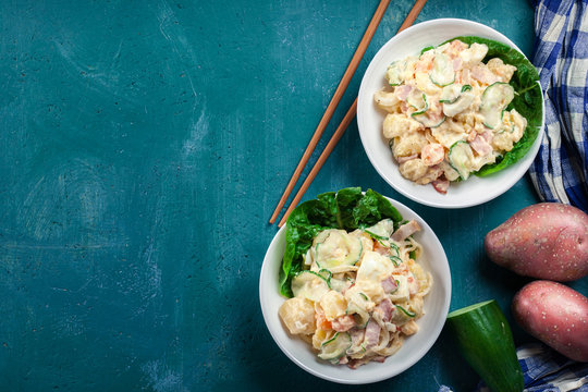 Delicious potato salad with ham, egg and cucumber