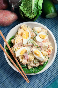 Delicious potato salad with ham, egg and cucumber